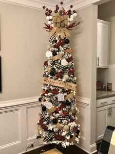 a christmas tree decorated with burlocks and bows in the corner of a kitchen