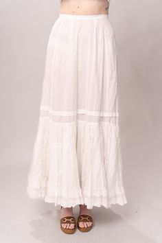 Stunning Edwardian 1910’s white cotton and lace maxi petticoat skirt. With a pretty flare silhouette, panel lace detail, and a button closure at waist. Good vintage condition, with normal wear and condition for its age. Some areas of visible mending a minor staining - see pictures. Best fits modern size XS/S Waist 26”Length 42” Featured top is the Blue Doll Quilt Corset from our friends at Psychic Outlaw. Model’s Measurements:Height 5’9”Chest 34”Waist 29”Hips 36.5” White Lace Patchwork Long Skirt, Vintage Long Lace Skirt, Daywear Long Lace Skirt, Vintage White Gathered Skirt Bottoms, White Lace Vintage Bottoms, Vintage White Lace Bottoms, White Vintage Lace Bottoms, Lace Trim Maxi Skirt For Wedding, Flowy Wedding Maxi Skirt With Lace Trim