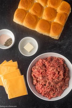 ingredients to make hamburger sliders laid out on a black counter top, including cheese and ground beef