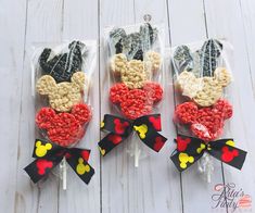 three mickey mouse lollipops in cellophane bags on a white wooden table