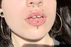 a woman with piercings on her nose and tongue