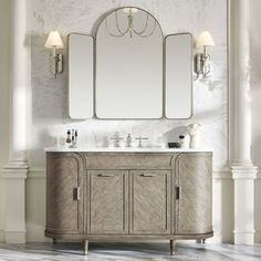 a bathroom vanity with three mirrors and two lights on the wall next to each other