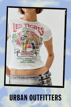 Baby tee with a Le Tigres printed at the front. Hits at the waist in a cropped silhouette with a crew neckline and cap sleeves. Find it exclusively at Urban Outfitters. Features Le Tigres graphic baby tee Tee with a Le Tigres graphic at the front Cropped silhouette Crew neckline UO exclusive Content + Care 100% Cotton Machine wash Imported Size + Fit Model in White is 5’10" and wearing size Small Measurements taken from size Small Chest: 24" Length: 17" | Le Tigres Baby Tee in White, Women's at Urban Outfitters Fitted Cotton Cropped T-shirt With Graphic Print, Trendy Fitted Top With Front Print, Spring Short Sleeve Crop Top With Logo Print, Fitted Graphic Tee From Urban Outfitters, Graphic Tee With Logo Print, Cropped Style, Urban Outfitters Text Print Crew Neck Top, Graphic Cropped T-shirt With Logo Print, Urban Outfitters Crew Neck Top With Text Print, Urban Outfitters Cotton Tops With Text Print