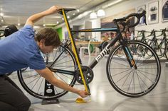 a man working on a bicycle in a bike shop