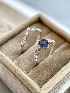 an engagement ring in a box with its own diamond and sapphire set on the side