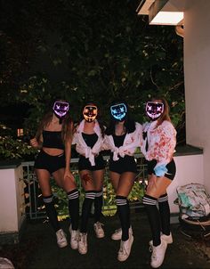 three girls in halloween costumes posing for the camera with their faces painted like pumpkins