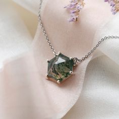 Be special with our moss agate necklace made in a delicate and minimalist style. Please choose the material and length from the drop down menu. In case if you prefer other shape or different gemstone - feel free to contact me, I will be happy to create custom hexagon shaped necklace.✨ Product details: Gemstone: Moss agate Measurements: 10x10mm Shape: Hexagon Material: 14k gold/Silver Total weight: 2.5g 🛠Handcrafted with love from our workshop in Prague.🛠 CERTIFICATION📃 Each piece of jewelry i Minimalist Agate Gemstone Necklace, Minimalist Pendant Necklace With Natural Inclusions, Elegant Faceted Hexagon Necklace, Elegant Hexagon Faceted Necklace, Hexagon Faceted Necklace For Gifts, Elegant Moss Agate Pendant Necklace, Hexagon Gemstone Necklace As A Gift, Hexagon Faceted Necklace For Gift, Hexagonal Gemstone Necklace As Gift