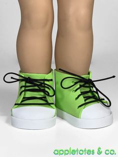 a pair of green shoes with black laces on the bottom and white soles