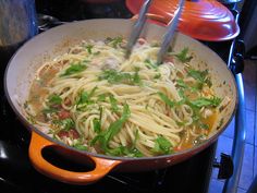 a pan filled with pasta and vegetables cooking on the stove