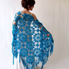 a woman wearing a blue crocheted shawl