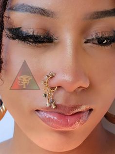 a close up of a person with a nose ring and piercing on their nose,