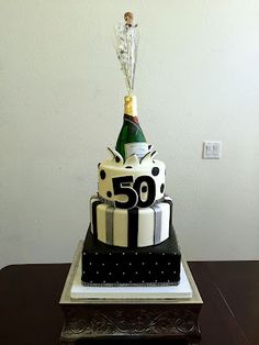 a 50th birthday cake with a bottle of wine on top