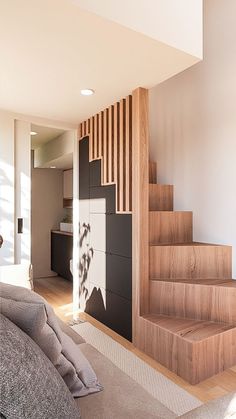 a living room filled with furniture next to a stair case