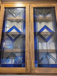 two stained glass doors with gold handles on each side and blue trim around the edges