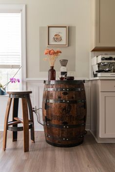 a wooden barrel sitting on top of a hard wood floor next to a kitchen counter