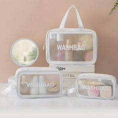 three white wash bags sitting next to each other on top of a table with a mirror