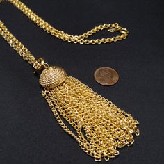 *Description: This is a gold tone Sarah Coventry tassel necklace from the 1970s. Sarah Coventry made a lot of their jewelry with a spring ring pendant so you could wear the chain by itself or with the detachable pendant. This tassel has a large spring ring and 24 chains which hang below a beehive shape. The chain also has a smaller spring ring clasp. This necklace hangs beautifully and at the same time is very light in weight. It would make a great gift or a wonderful addition to your vintage je Gold Tassel Dangle Necklace Gift, Gold Metal Tassel Dangle Necklace, Gold Metal Dangle Tassel Necklace, Gold Tassel Dangle Necklace, Gold Metal Tassel Jewelry, Gold Metal Jewelry With Tassels, Gold Tassel Necklace With Adjustable Chain, Gold Long Tassel Necklace, Gold Long Necklace With Tassels