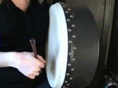 a woman is working on an object in the process of making it look like a drum