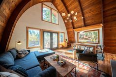 a living room filled with furniture and lots of wooden walls on top of a roof