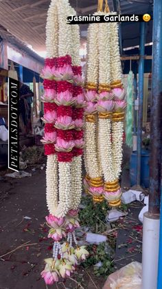 flower garlands hanging from the ceiling in a market place with flowers all over them