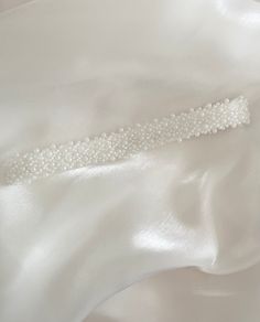 Introducing our Bespoke and Elegant Wedding Garter Adjourned with Small White Beads.    This bead adjourned garter is all about comfort and style. Crafted from stretchy elastic. It is customized and designed to fit perfectly, ensuring you're at ease as you dance the night away. All Olivelli Bridal garters are delicately hand-stitched. Crafted with love and attention to detail, this garter is more than an accessory - it's a cherished keepsake! MAKE MEMORIES LAST - Compliment your main garter with a beautiful toss garter, and cherish one as a keepsake garter.  UNIQUELY BESPOKE - Our garters are delicately hand-stitched creating an exclusive design with unmatched quality. - Perfect Bridal Gift: A heartfelt gift that will be treasured for years to come. - Beautifully Wrapped: Each garter comes Bridal Garters, Wedding Garters, Gift For Bride, Bridal Garter, Wedding Garter, Bridal Gift, Bespoke Wedding, Heartfelt Gifts, Bridal Gifts