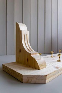 a wooden board with two golden faucets on it