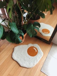 an egg shaped rug is on the floor next to a mirror and potted plant