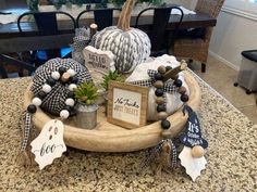 a wooden tray filled with decorative items on top of a kitchen counter next to a dining room table