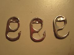 three fish hooks from can tabs hanging on a wall with the words diy