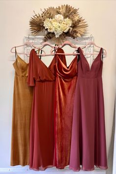 four bridesmaid dresses hanging on a rack