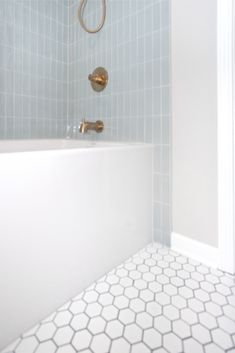 a white bath tub sitting next to a shower head