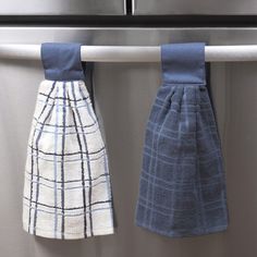 two kitchen towels hanging from the handle of an appliance, one blue and one white