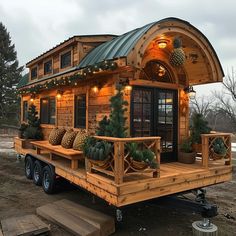 a small wooden cabin with lights on the roof and porch is parked in front of a house