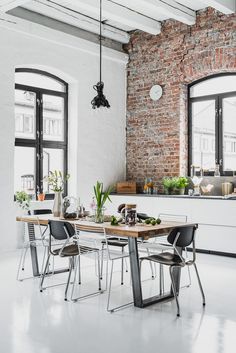 an industrial style kitchen and dining room with exposed brick walls