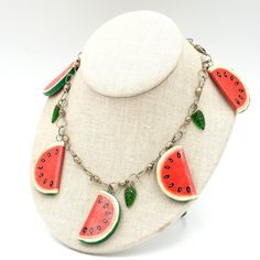 "A charming hand painted wooden watermelon necklace with glass leaf dangles. Super cute statement! Unmarked/unsigned. This necklace has been loved and there is wear commensurate with age with a few chips to the paint, see photos. Overall it is in good wearable condition. Length: 26.5\" Long but can be worn shorter  (watermelon is 1.7\" tall) Weighs: 39 grams Please feel free to contact me with questions and/or for additional photos. More unique pieces in the shop: Colorful wooden necklace - https://basefare.etsy.com/listing/1195607578 Papier mache fruits and veggie necklace -  *Free Shipping on Domestic Orders Over $35* All orders ship USPS Ground Advantage. If you would like to add insurance please reach out before purchase. All of our items are in good, vintage condition because of their Adjustable Fun Fruit Design Jewelry, Watermelon Bead Necklace, Cheap Playful Jewelry With Fruit Design, Handmade Watermelon Colored Dangle Jewelry, Watermelon Necklace, Fruit Jewelry, Boho Bedroom Decor, Wooden Necklace, Statement Jewelry