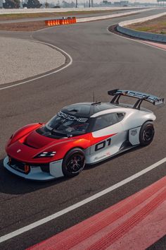 an orange and white sports car driving on a race track