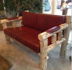 a red leather couch sitting in front of a wooden table