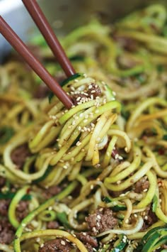 stir fried noodles with beef and vegetables in a wok, ready to be eaten