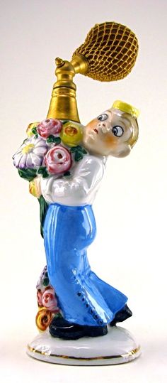 a glass figurine holding a gold trophy with flowers on it's head