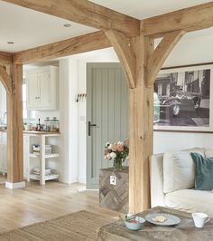 a living room filled with furniture and wooden beams