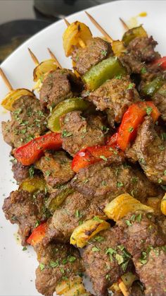 meat and vegetable skewers on a plate with toothpicks in the foreground