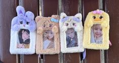 three stuffed animals hanging on the side of a wooden fence with pictures in them and two children's faces