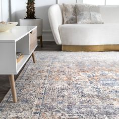 a living room area with a couch, coffee table and rug