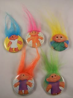 four trolly hair buttons with different colors on them