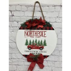 a sign hanging on the side of a brick wall that says north pole tree farm