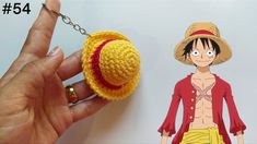 a hand holding a crocheted keychain with one piece of clothing on it