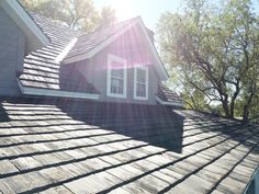 the roof of a house with shingles and trees in the backgrouds