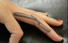 a woman's hand with a knife tattoo on it