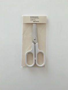 a pair of white scissors sitting on top of a package