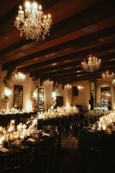 a dining room with chandeliers and tables set up for an elegant dinner party